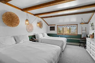 a bedroom with two beds and a table and a window at Jessie's Harvest House in Tannersville