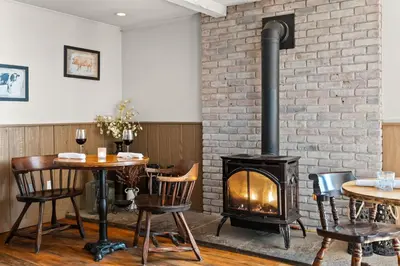 a fireplace in a restaurant with tables and chairs at Jessie's Harvest House in Tannersville