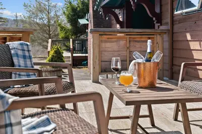 a wooden table with a glass of wine on a patio at Jessie's Harvest House in Tannersville
