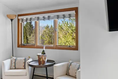 a living room with two chairs and a table and a window at Jessie's Harvest House in Tannersville