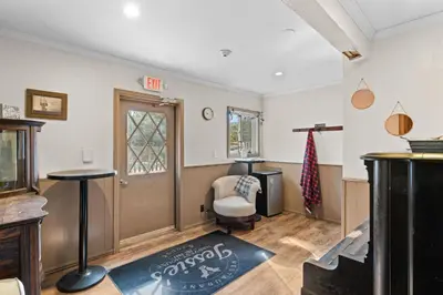 a living room with a chair and a door at Jessie's Harvest House in Tannersville
