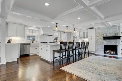 a kitchen with white cabinets and a fireplace at Luxury Stay In Expansive Historical Home in North Haven