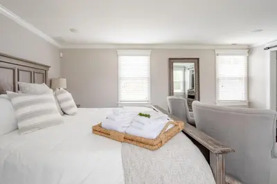 a white bedroom with a bed and chairs at Luxury Stay In Expansive Historical Home in North Haven