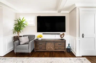 a living room with a tv on a wall at Luxury Stay In Expansive Historical Home in North Haven