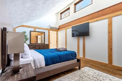 a bedroom with a bed and a flat screen tv at Modern Rustic Lodge! Game Room in Saw Creek