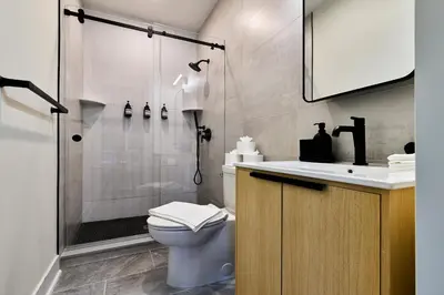 a bathroom with a shower and a toilet and a sink at Hoboken Loft Hideaway - walk to PATH in Hoboken
