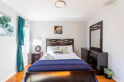 a bedroom with a large bed and a mirror at Mahogany Sun Hot Tub Theater Room Fire Pit in East Stroudsburg