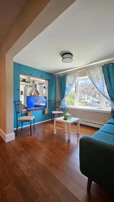 a living room with blue walls and a blue couch at The Heart of Hicksville House in Hicksville