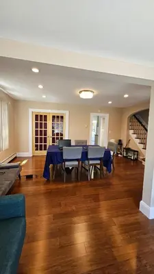 a dining room with a blue table and chairs at The Heart of Hicksville House in Hicksville
