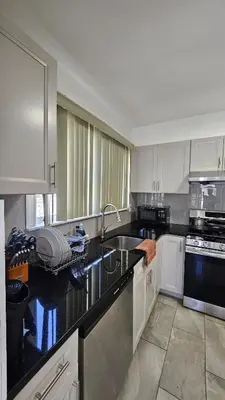 a kitchen with a sink and a counter top at The Heart of Hicksville House in Hicksville