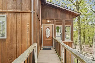 a wooden house with a wooden walkway leading to the door at Charming Porter House in the heart of the Poconos chalet in East Stroudsburg