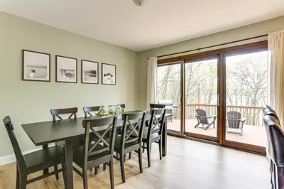 a dining room with a table and chairs and a balcony at half Mi to Boat Ramp Lake Wallenpaupack Retreat! in Lakeville