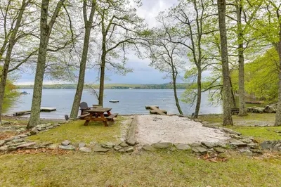 a picnic table and bench next to a lake at half Mi to Boat Ramp Lake Wallenpaupack Retreat! in Lakeville