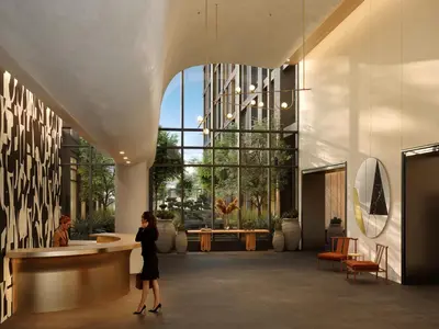 a woman standing in the lobby of a building at The Rhyland in Flushing