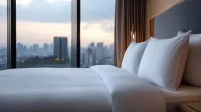 a bed with white pillows in front of a window at The Rhyland in Flushing