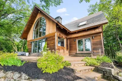 a log home with a porch and stairs leading to it at Catskill Estate epic views hot tub in Kingston