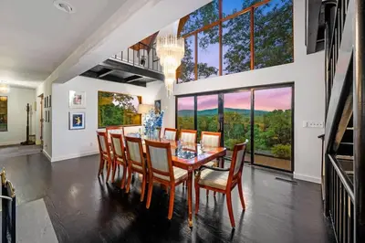 a dining room with a table and chairs and a large window at Catskill Estate epic views hot tub in Kingston