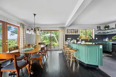 a dining room with a green island and tables and chairs at Catskill Estate epic views hot tub in Kingston