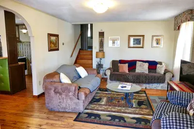 a living room with two couches and a table at Lakefront Cabin Rental with Incredible Sunsets on Lake Wallenpaupack, Pennsylvania in Hawley