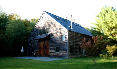 an old wooden barn with a wooden door at Boutique Barn Vacation Rental in Hudson Valley and Two Hours from New York City in Saugerties