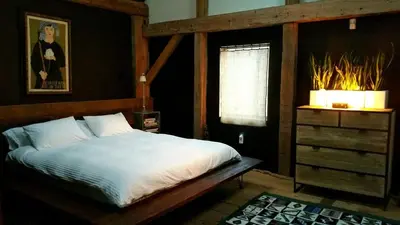 a bedroom with a bed and a window and a dresser at Boutique Barn Vacation Rental in Hudson Valley and Two Hours from New York City in Saugerties