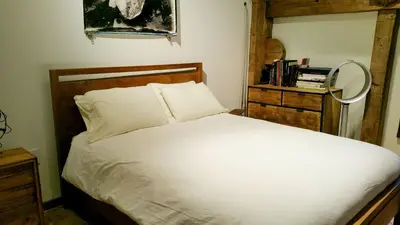 a bedroom with a white bed and a mirror at Boutique Barn Vacation Rental in Hudson Valley and Two Hours from New York City in Saugerties
