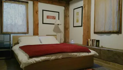 a bedroom with a bed with a red blanket on it at Boutique Barn Vacation Rental in Hudson Valley and Two Hours from New York City in Saugerties