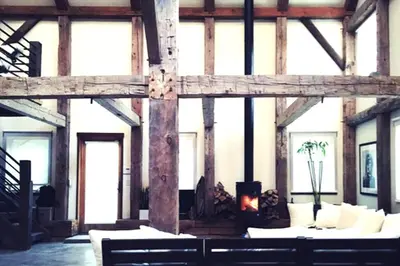 a large wooden building with couches and a fireplace at Boutique Barn Vacation Rental in Hudson Valley and Two Hours from New York City in Saugerties