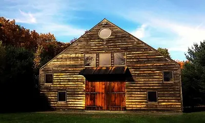 an old wooden barn with its door open at Boutique Barn Vacation Rental in Hudson Valley and Two Hours from New York City in Saugerties