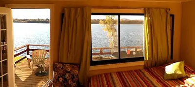 a bedroom with a window with a view of the water at Comfortable Cabin Right on Great Sacandaga Lake in Northville, New York in Northville