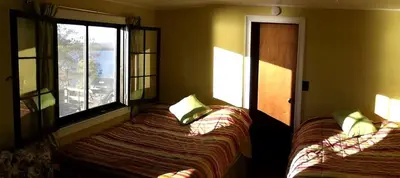 a bedroom with two beds and a window at Comfortable Cabin Right on Great Sacandaga Lake in Northville, New York in Northville