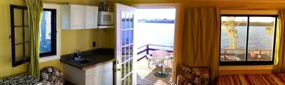 a room with a kitchen and a balcony with a view at Comfortable Cabin Right on Great Sacandaga Lake in Northville, New York in Northville
