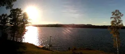 a lake with the sun shining on the water at Comfortable Cabin Right on Great Sacandaga Lake in Northville, New York in Northville