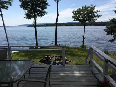a wooden deck with a view of a lake at Cozy Cabin with Lovely Views of Great Sacandaga Lake in Northville, New York in Northville