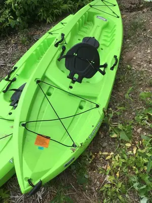 a green kayak is sitting on the grass at Cozy Cabin with Lovely Views of Great Sacandaga Lake in Northville, New York in Northville