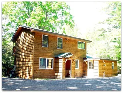 a small wooden house with a lot of windows at Romantic Cottage Rental with Hot Tub Outside Woodstock, New York in Bearsville