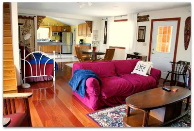 a living room with a purple couch and a table at Romantic Cottage Rental with Hot Tub Outside Woodstock, New York in Bearsville