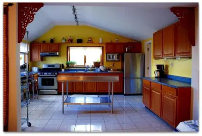 a kitchen with wooden cabinets and a sink and a refrigerator at Romantic Cottage Rental with Hot Tub Outside Woodstock, New York in Bearsville