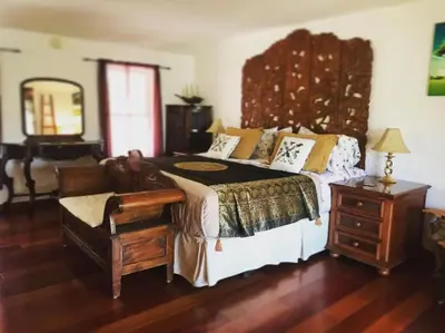 a bedroom with a large bed with a wooden headboard at Romantic Cottage Rental with Hot Tub Outside Woodstock, New York in Bearsville
