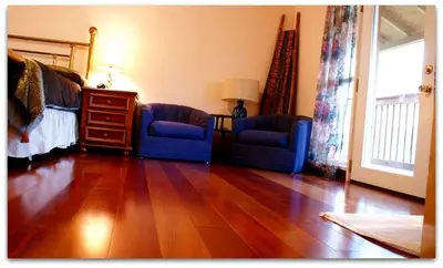 a living room with two blue chairs and a wooden floor at Romantic Cottage Rental with Hot Tub Outside Woodstock, New York in Bearsville