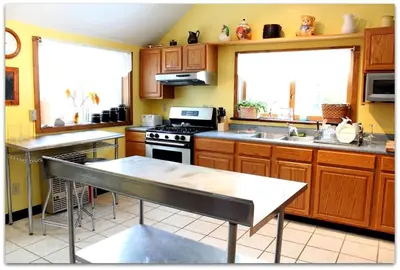 a kitchen with wooden cabinets and a stove top oven at Romantic Cottage Rental with Hot Tub Outside Woodstock, New York in Bearsville