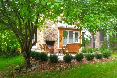 a stone house with chairs and a table and a tree at Secluded Cottage Rental with a Heated Pool in Red Hook for Family Getaways in New York State in Red Hook