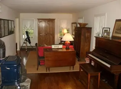a living room with a piano and a table at Secluded Cottage Rental with a Heated Pool in Red Hook for Family Getaways in New York State in Red Hook