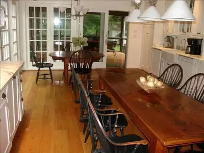 a dining room with a wooden table and chairs at Secluded Cottage Rental with a Heated Pool in Red Hook for Family Getaways in New York State in Red Hook