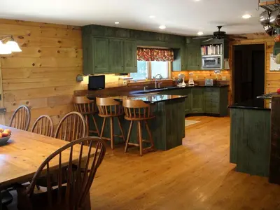 a kitchen with green cabinets and a wooden floor at Bed and Breakfast Cabin for Weekend Getaway near Millbrook, New York in Dover Plains