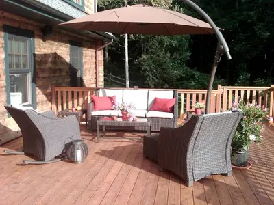 three chairs and an umbrella on a patio at Bed and Breakfast Cabin for Weekend Getaway near Millbrook, New York in Dover Plains