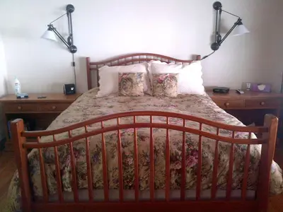 a bed with a wooden headboard and pillows at Bed and Breakfast Cabin for Weekend Getaway near Millbrook, New York in Dover Plains
