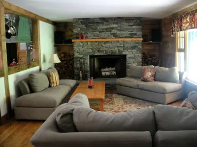 a living room with couches and a stone fireplace at Bed and Breakfast Cabin for Weekend Getaway near Millbrook, New York in Dover Plains