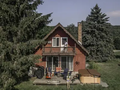 a dog sitting on the balcony of a house at Rustic Cabin Rental with a Hot Tub near Windham, New York in Windham
