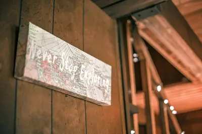 a sign on a wooden wall next to a bench at Rustic Cabin Rental with a Hot Tub near Windham, New York in Windham